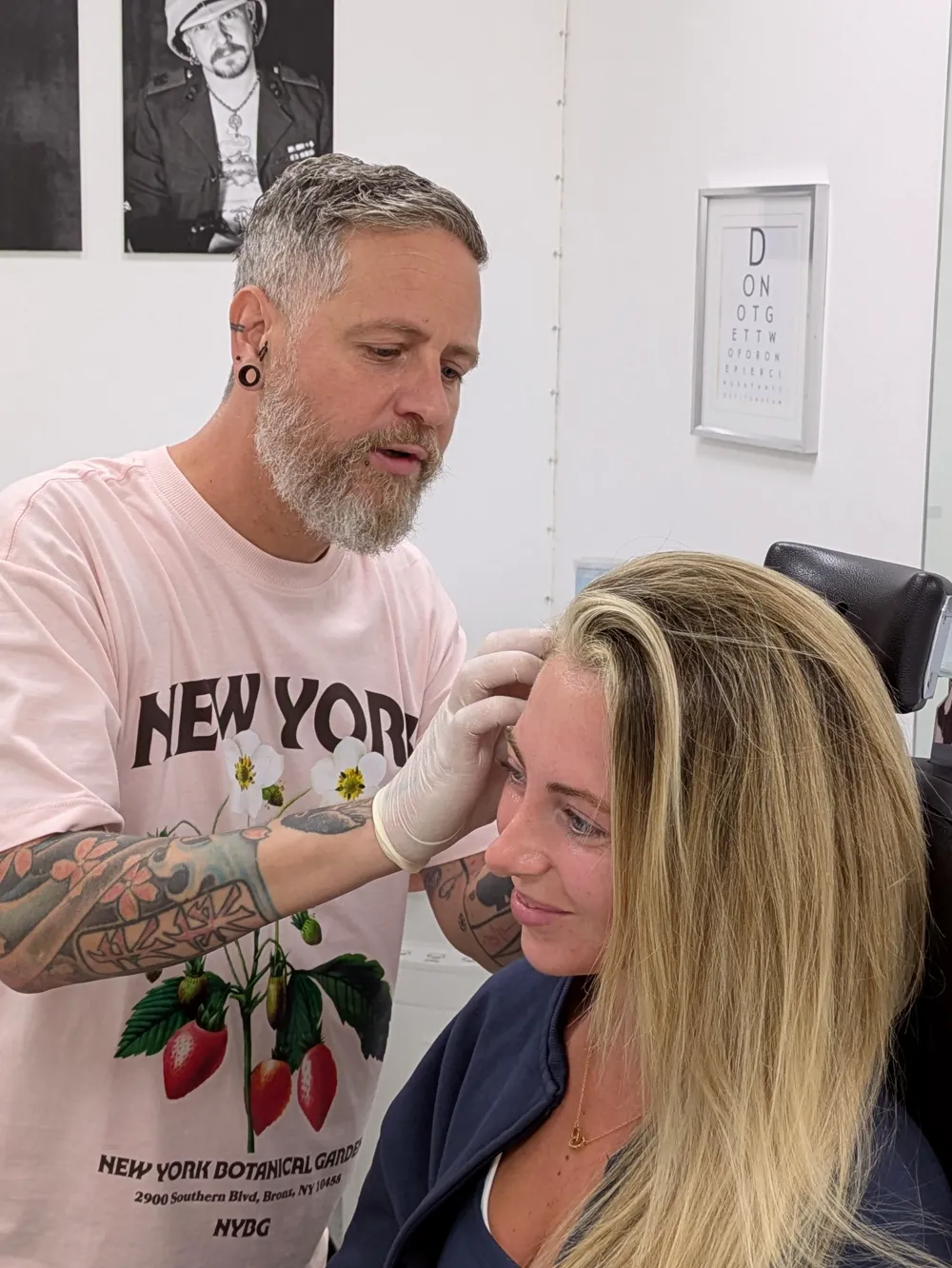 A person piercing a smiling clients' ear at Metal Fatigue Piercing in Bournemoutht