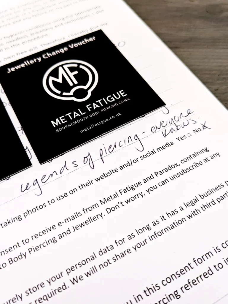Close up of a consent form with a handwritten note saying, 'legends of piercing - everyone knows'