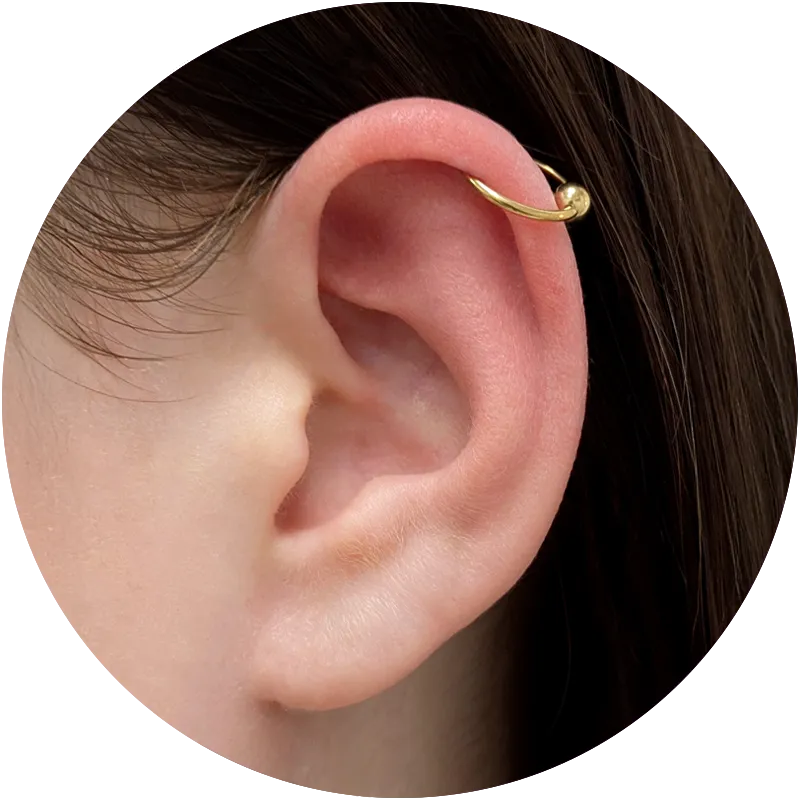 Close up of an ear with a helix piercing with a gold hoop