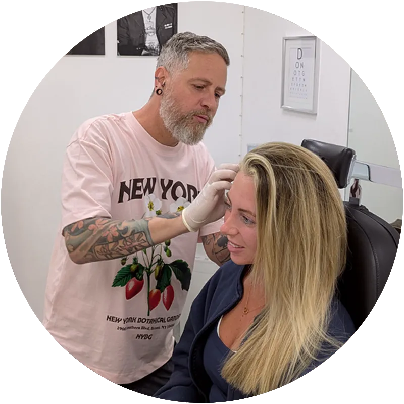 A piercer changing a smiling clients ear jewellery at Metal Fatigue in Bournemouth