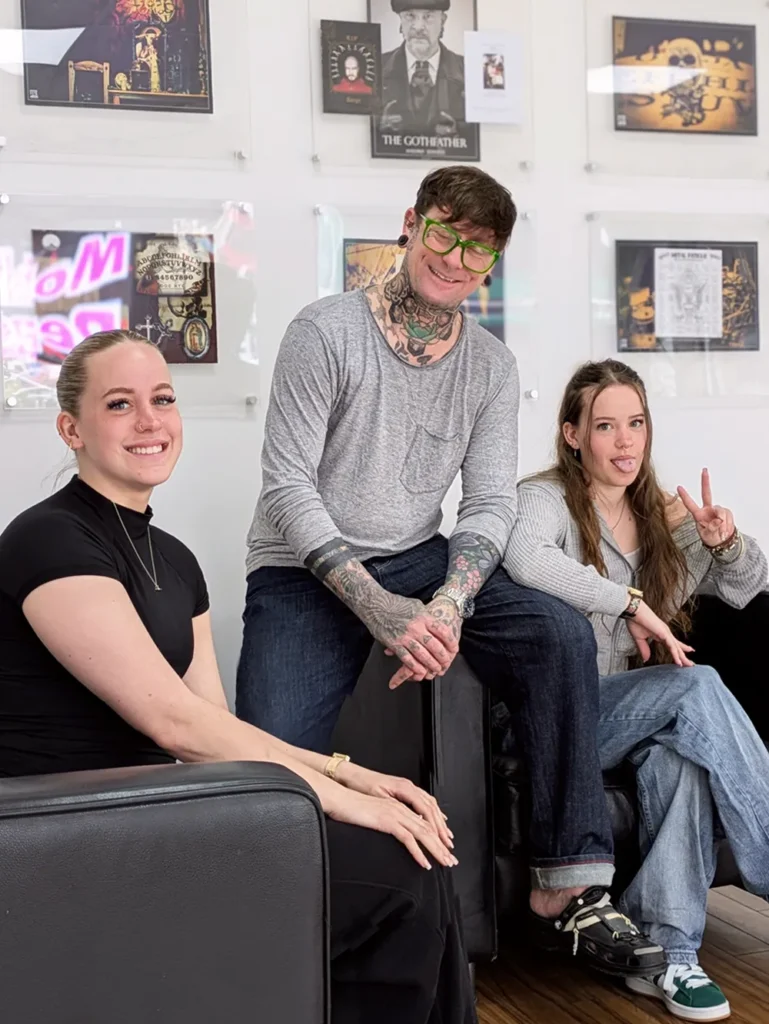Bournemouth body piercer AJ smiling with his two daughters in Metal Fatigue in Bournemouth