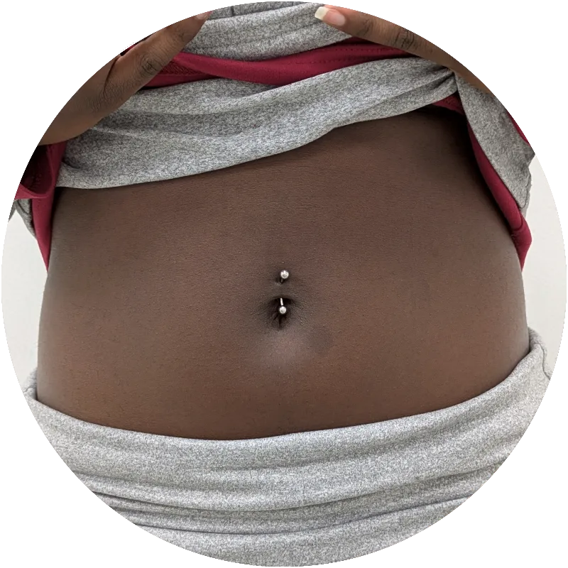 Close up of a belly button piercing