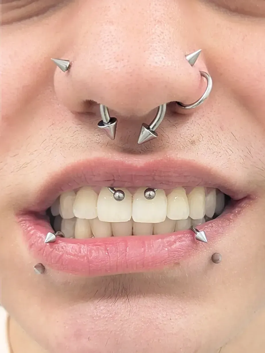Close up of a nose and mouth with multiple piercings