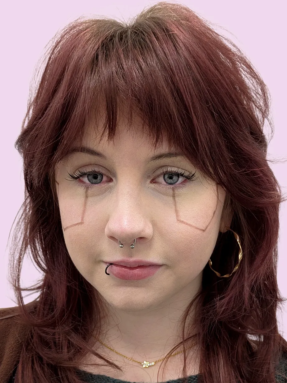 Portrait of a person with striking lined make up and a labret piercing