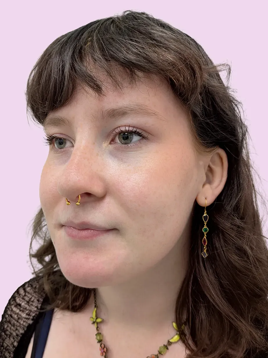 Portrait of a woman with brown hair and a gold septum piercing