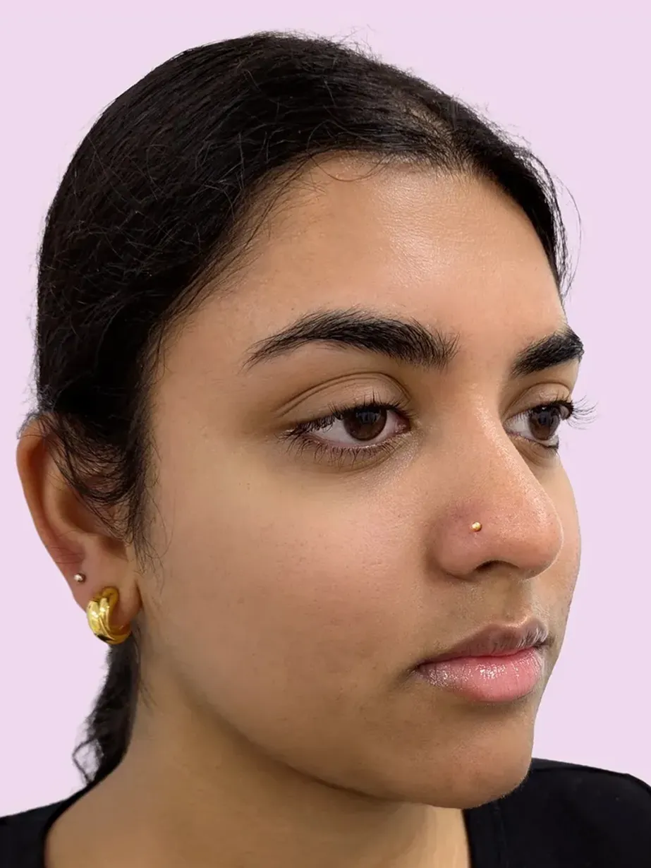 Portrait of a woman with dark hair and a gold nose piercing stud