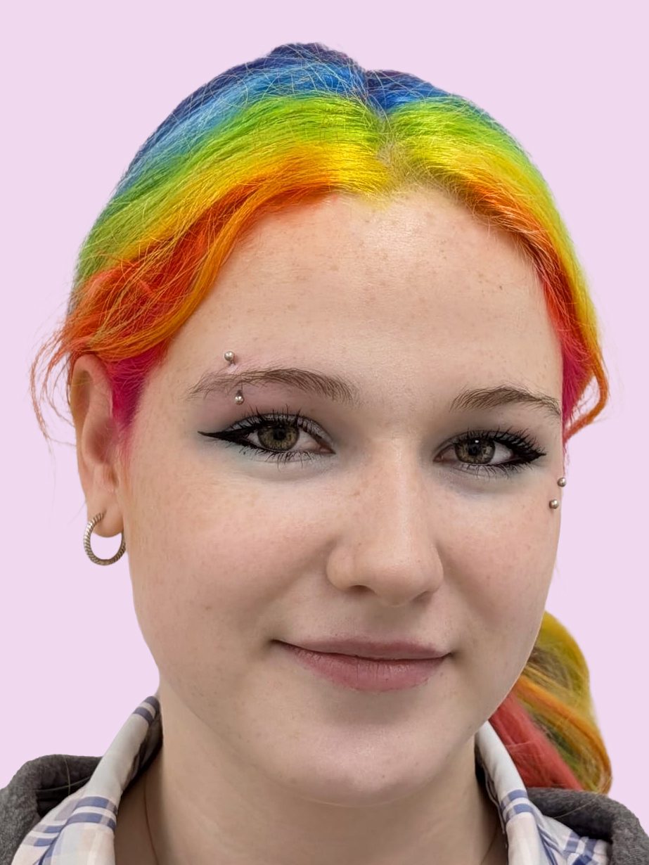 Portrait of a woman with rainbow coloured hair and an eyebrow piercing and an anti eyebrow piercing