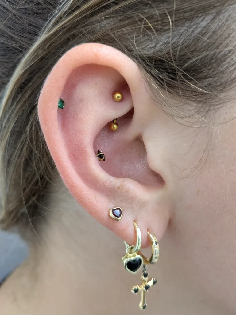 Close up of an ear with a conch, rook, helix and earlobe piercings